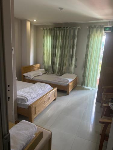 a bedroom with two beds and a window at Hoa Mai Hotel in Trạm Chánh An
