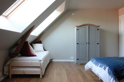 a attic bedroom with a bed and a cabinet at Spacious apartment in the country side in Vellinge