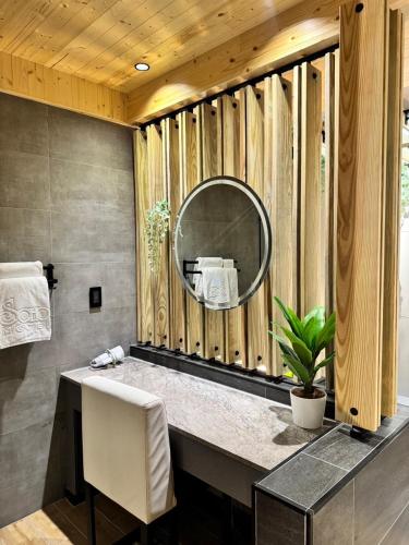 a bathroom with a mirror on a wooden wall at Soho Motel in Taoyuan