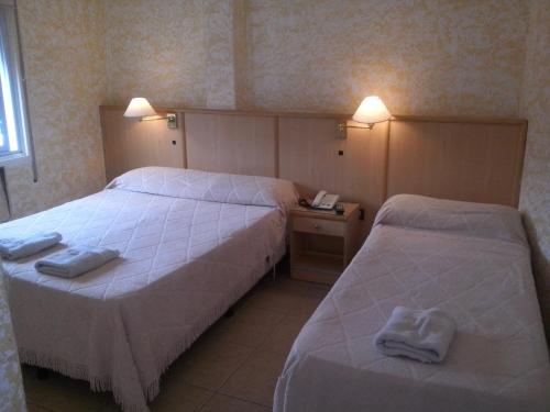 2 letti in camera d'albergo con asciugamani di Hotel Mónaco a Villa Carlos Paz