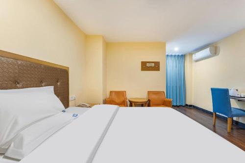 a bedroom with a bed and chairs and a table at shenzhen kaixin Hotel in Shenzhen