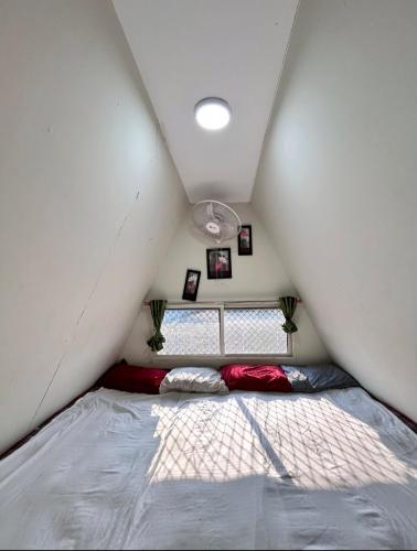 a bed in a small room with a window at Rk Farm's in Hyderabad