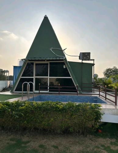 a pyramid building with a pool in front of it at Rk Farm's in Hyderabad