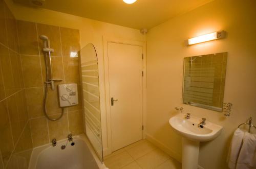 a bathroom with a sink and a tub and a shower at Kenmare Bay Hotel Holiday Homes in Kenmare