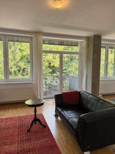 a living room with a black leather couch and a table at K9 Wohnungen in Münster