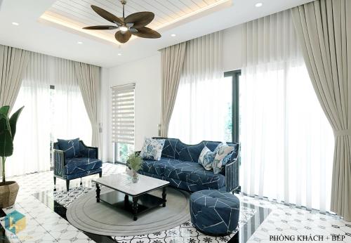 a living room with a blue couch and a ceiling fan at Bali Villa- Đối diện Tropicana Park - Novaworld Hồ Tràm in Ho Tram