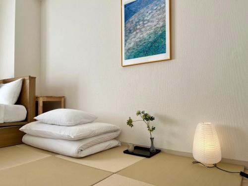 a bedroom with a bed and a table with pillows at Comfy Home Kikukawa in Tokyo