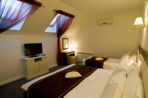 a hotel room with two beds and a tv at Villa Rossa Hotel in Chişinău