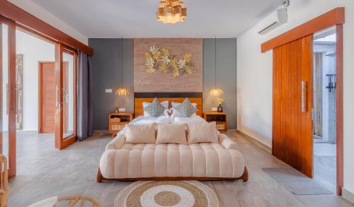 a large bedroom with a large bed and a chandelier at Villa Dunia Lembongan in Nusa Lembongan