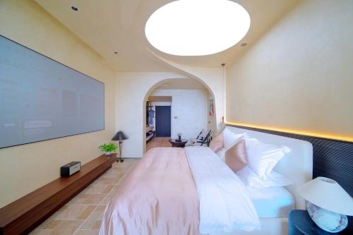 - une chambre avec un grand lit et un grand écran dans l'établissement Yasong Jianwen Resort Hotel, à Diaolongzui