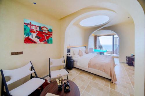 une chambre avec un lit, une table et des chaises dans l'établissement Yasong Jianwen Resort Hotel, à Diaolongzui