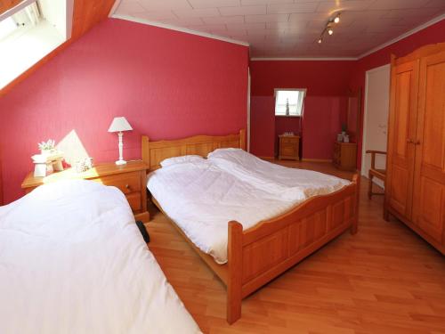 Un dormitorio con dos camas y una pared roja. en Villa in Middelkerke near the Beach, en Middelkerke