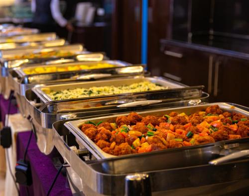 a row of trays of food in a buffet at Azzeman Hotel in Addis Ababa