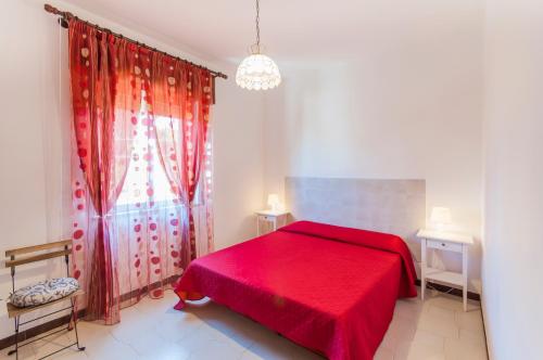 a bedroom with a red bed and a window at Villa Saracena in Castellammare del Golfo