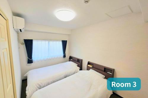 a room with two beds and a window at Vacation House 2 in Funabashi