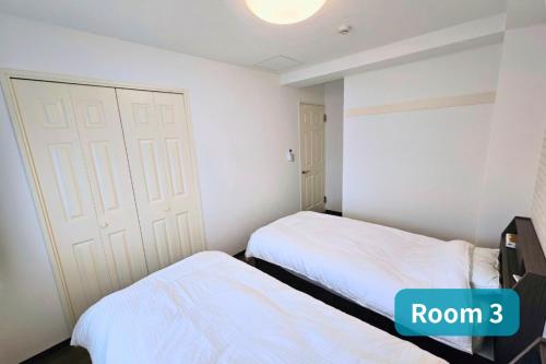 a bedroom with two beds and a white door at Vacation House 2 in Funabashi