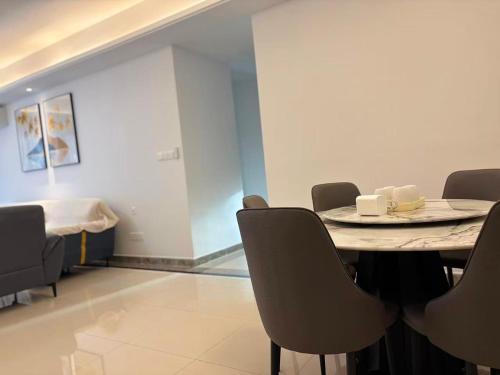 a room with a table and chairs and a bed at TheBess Hotel Tokyo is located adjacent to Singapore and offers a sea viewIt is a family business smart room with the sea view of Princess Bay富力公主湾 in Johor Bahru