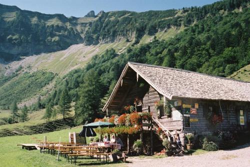 a restaurant with tables and chairs in front of a mountain at DAS Hintersee in Hintersee