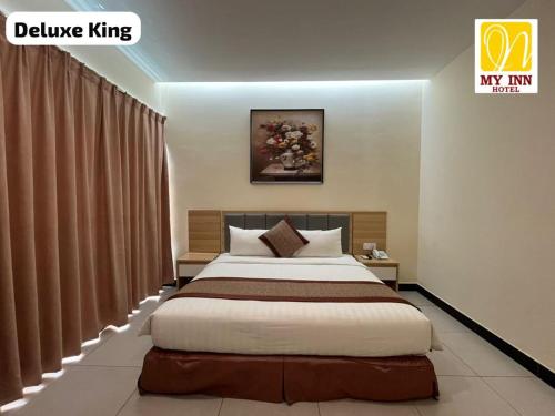 a bedroom with a large bed in a room at My Inn Hotel Inanam in Inanam