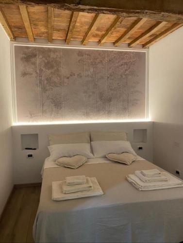 a bedroom with a bed with two towels on it at Frattina1860 in Montisi