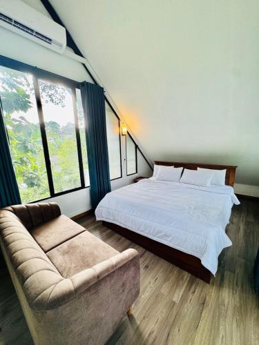 a bedroom with a large bed and a couch at Willow Nest Apartments in Sri Jayewardenepura Kotte