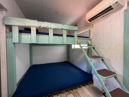 a room with two bunk beds and a ladder at あさひシーサイドコテージ in Asahi
