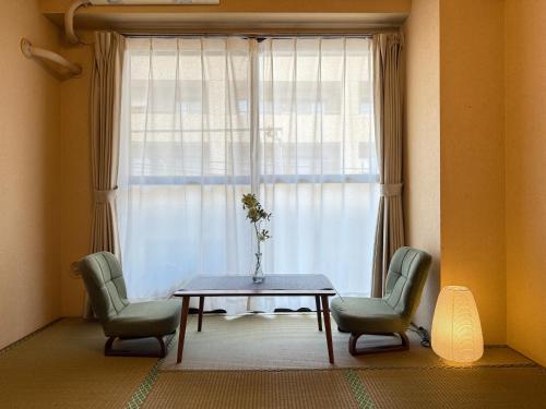 a room with a table and two chairs and a window at Comfy Home Kikukawa in Tokyo