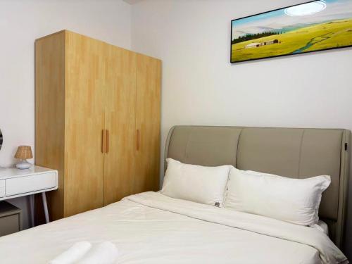 a bedroom with a bed and a wooden cabinet at TheBess Hotel Tokyo is located adjacent to Singapore and offers a sea viewIt is a family business smart room with the sea view of Princess Bay富力公主湾 in Johor Bahru