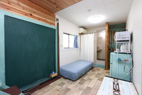 a classroom with a green chalkboard in a room at あさひシーサイドコテージ in Asahi