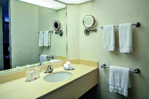 y baño con lavabo, espejo y toallas. en Hilton Vacation Club Varsity Club South Bend, IN, en South Bend