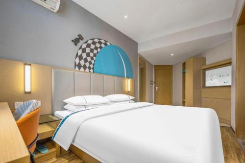 a bedroom with a large white bed in a room at City Comfort Inn Dangtu High Speed East Railway Station RT-Mart in Ma'anshan