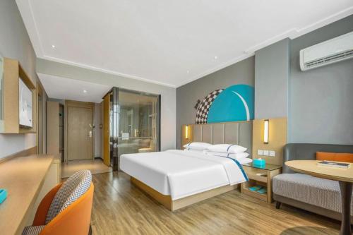 a bedroom with a large white bed and a desk at City Comfort Inn Dangtu High Speed East Railway Station RT-Mart in Ma'anshan
