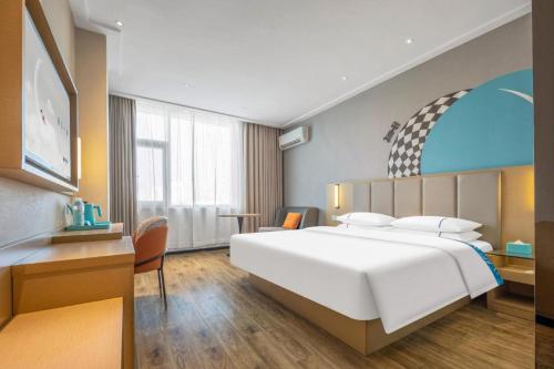 a bedroom with a large white bed and a desk at City Comfort Inn Dangtu High Speed East Railway Station RT-Mart in Ma'anshan