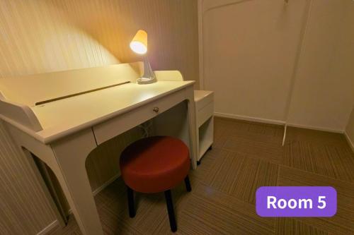 a desk with a red chair and a lamp on it at Vacation House 2 in Funabashi