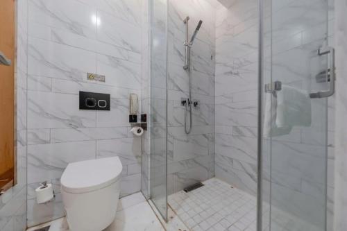 a white bathroom with a shower and a toilet at Jinjiang Metropolo Hotel Nanjing Confucius Temple Branch in Nanjing