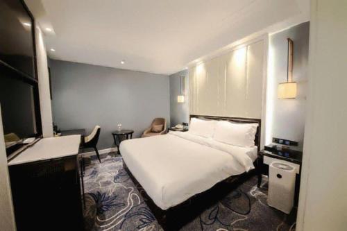 a bedroom with a large white bed in a room at Jinjiang Metropolo Hotel Nanjing Confucius Temple Branch in Nanjing