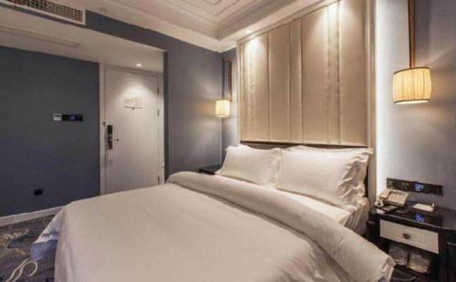 a bedroom with a large bed with white sheets at Jinjiang Metropolo Hotel Nanjing Confucius Temple Branch in Nanjing