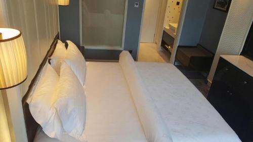 a bed with two pillows on it in a room at Jinjiang Metropolo Hotel Nanjing Confucius Temple Branch in Nanjing