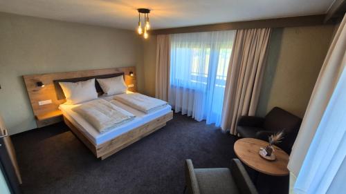 a hotel room with a bed and a table at Hotel Kniebis-Stuben in Kniebis