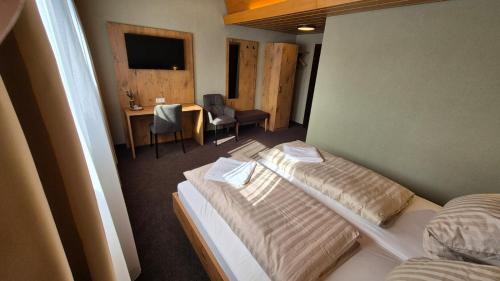 a hotel room with two beds and a table and chairs at Hotel Kniebis-Stuben in Kniebis