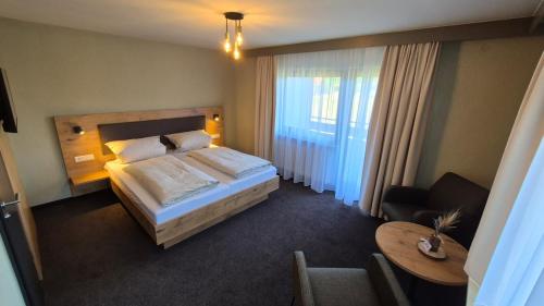 a hotel room with a bed and a table at Hotel Kniebis-Stuben in Kniebis