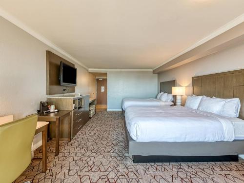 a hotel room with two beds and a television at Amanzi Hotel, an Ascend Collection Hotel in Ventura