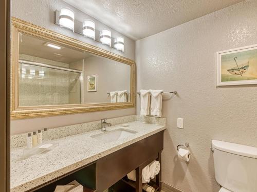 a bathroom with a sink and a mirror and a toilet at Amanzi Hotel, an Ascend Collection Hotel in Ventura