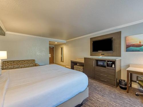 a hotel room with a large bed and a flat screen tv at Amanzi Hotel, an Ascend Collection Hotel in Ventura