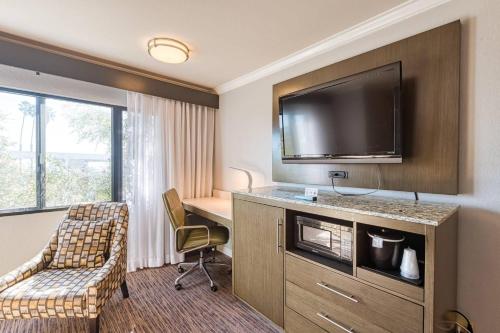 a hotel room with a desk and a flat screen tv at Amanzi Hotel, an Ascend Collection Hotel in Ventura
