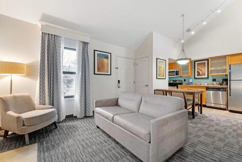 a living room with a couch and a table at MainStay Suites St Louis - Galleria in Richmond Heights