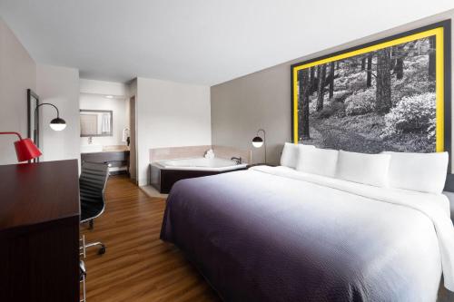 a hotel room with a large bed and a desk at Super 8 by Wyndham Helen in Helen