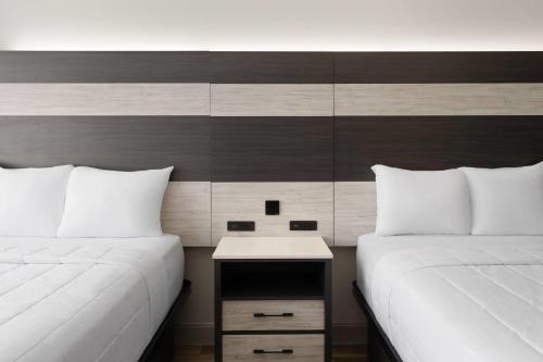two beds sitting next to each other in a room at Baymont by Wyndham Williamsburg I-64 in Williamsburg
