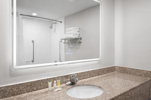 a bathroom with a sink and a large mirror at Baymont by Wyndham Williamsburg I-64 in Williamsburg