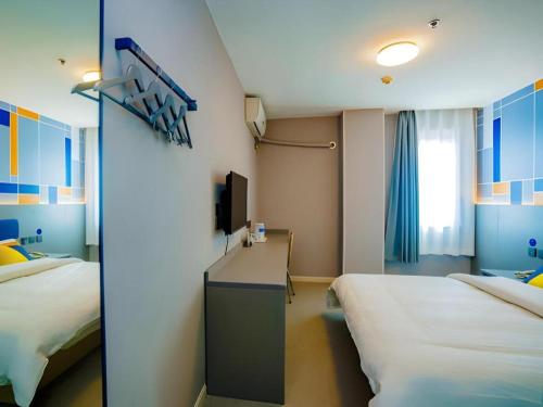 a hotel room with two beds and a tv at 7 Days Inn Xi'an Railway Station in Xi'an